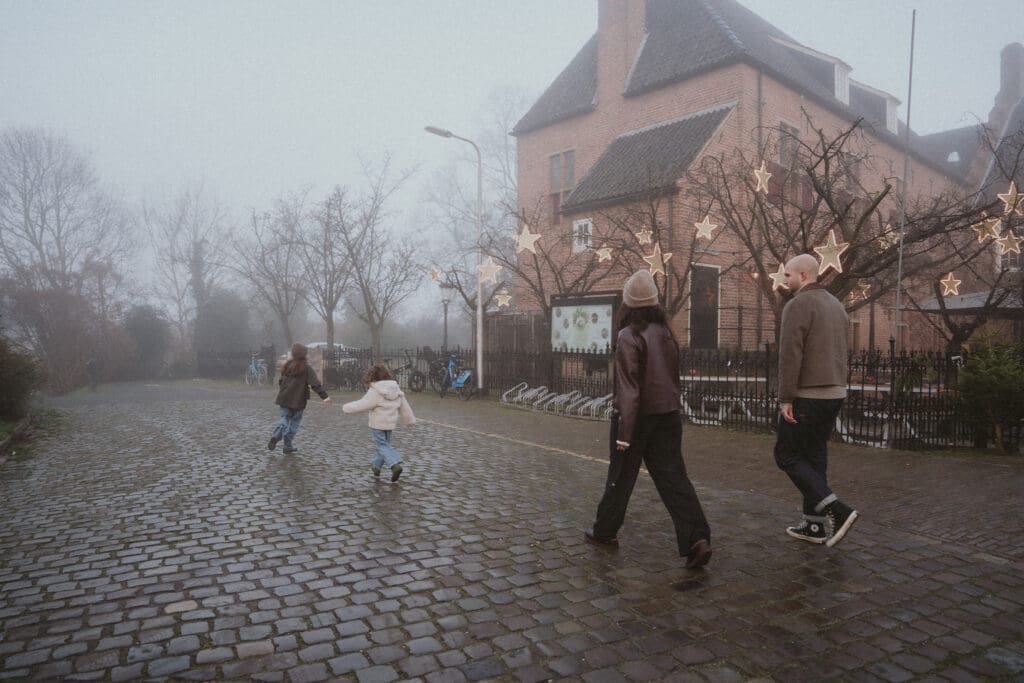 Gezin wandelend in de mist door de stad Nijmegen. Rennende kinderen